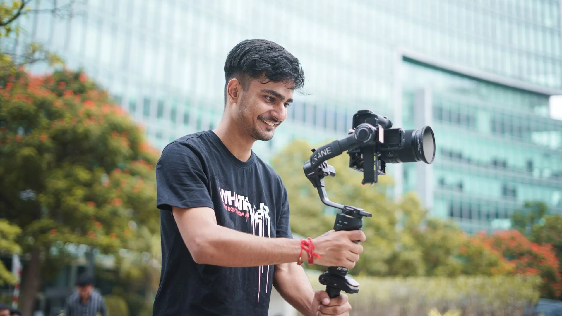 Young Indian videographer filming outdoors with a camera on a gimbal